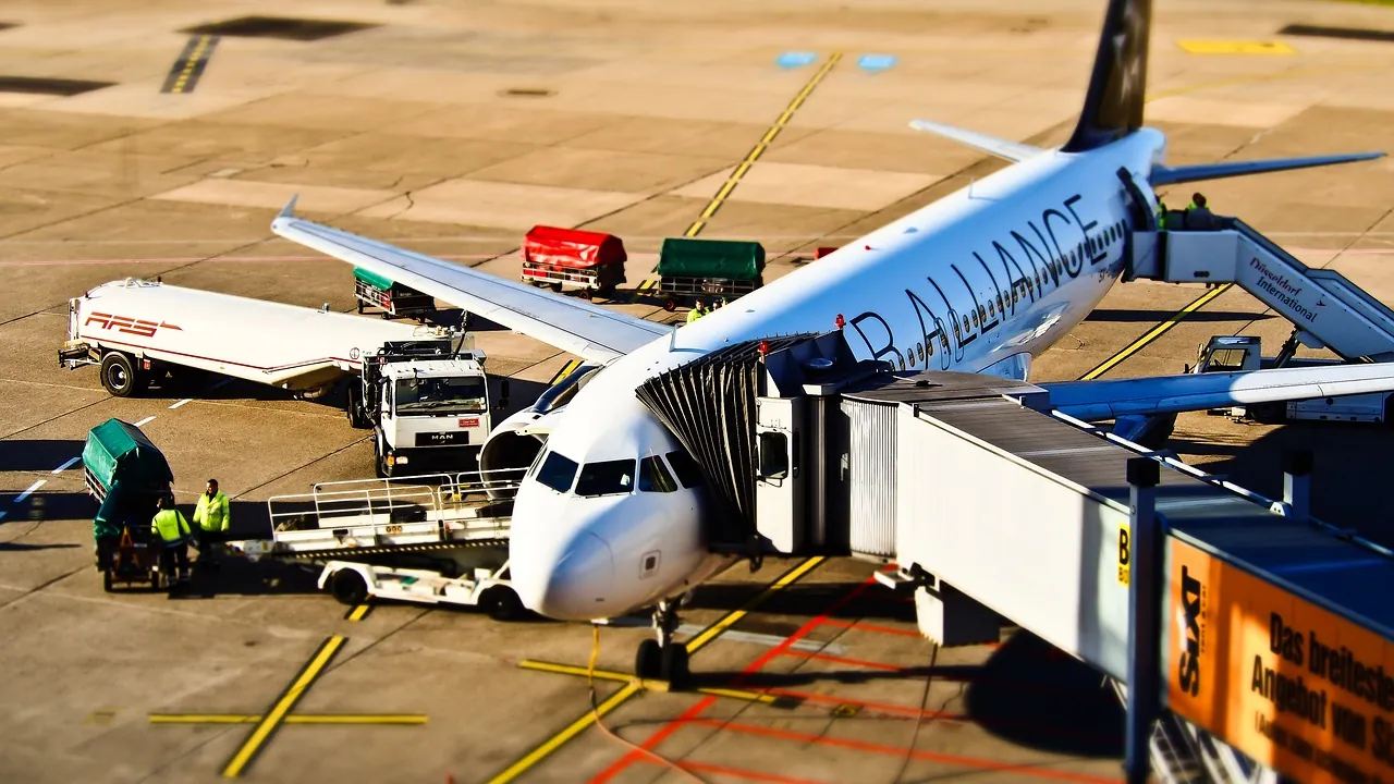 Équipe de piste autour d’un avion à la porte d’embarquement, en pleine préparation du vol