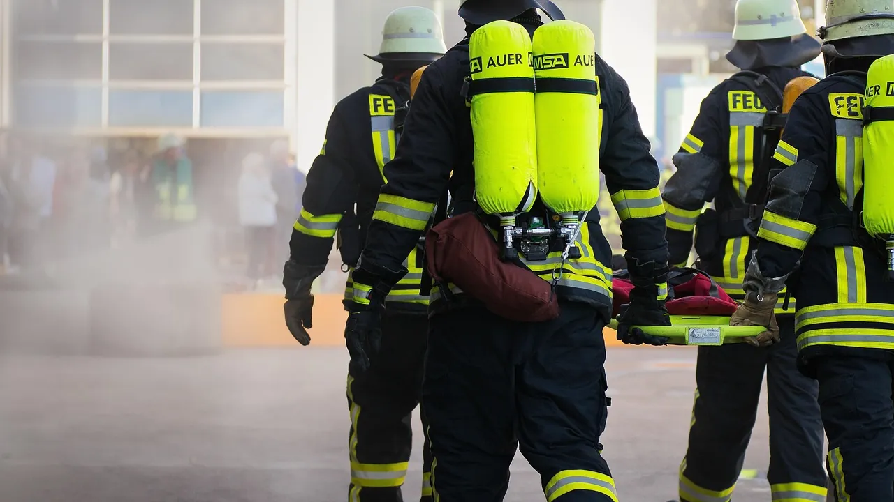 Pompiers de dos, équipés de leurs bouteilles d’air, en route vers l’intervention