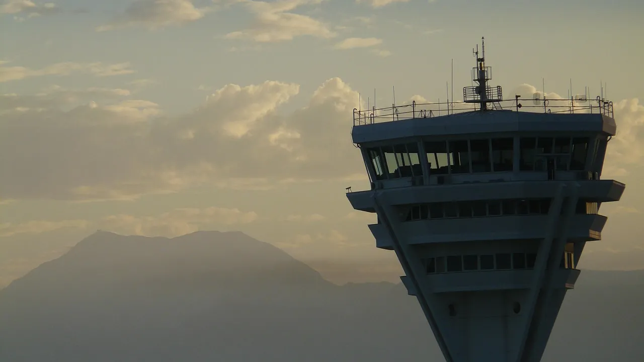 Tour de contrôle d’un aéroport dominant la plaine au soleil couchant